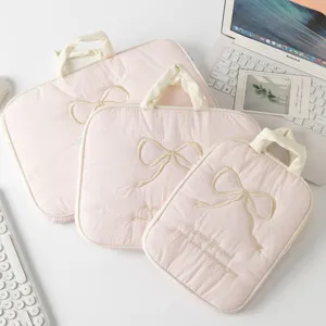 Vista detallada de tres tamaños de fundas rosas acolchadas con lazo bordado para PC