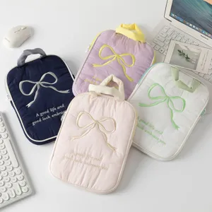 Vista superior de varias fundas acolchadas con lazo bordado para iPad y portátil