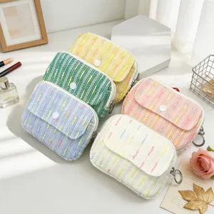 Multi-colored tweed coin pouches with flap buttons for lipstick and cosmetics storage.