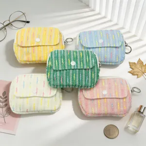 Collection of colorful tweed mini purses with flip-top buttons and keychain rings.