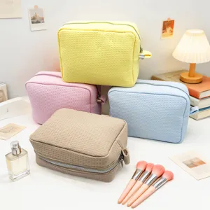 Neceser con textura de gofre multicolor con brochas de maquillaje y accesorios