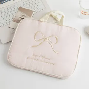 Vista detallada de funda acolchada rosa para portátil con diseño de lazo bordado elegante
