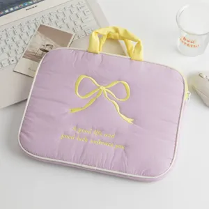 Primer plano del bordado de lazo amarillo en una funda protectora morada para portátil