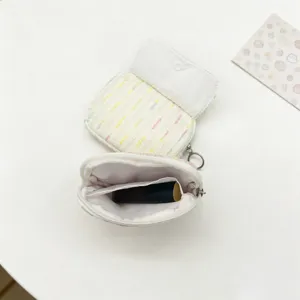 Detail view of tweed mini coin purse and lipstick pouch with interior storage space
