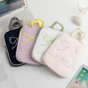 Fundas acolchadas para portátiles en tonos pastel con lazos bordados y asas de mano