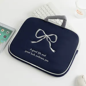 Primer plano de la funda para tableta azul marino con lazo bordado blanco puro.