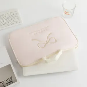 Detalle del bordado de lazo intrincado en una funda rosa suave para ordenador portátil