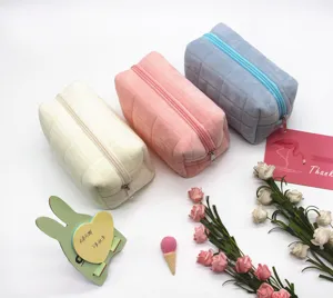 Set aus drei pastellfarbenen gesteppten Samtbeuteln in Weiß, Pfirsich und Blau