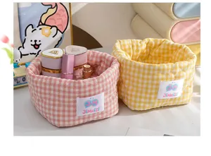 Détail de paniers de rangement en tissu vichy matelassé rose et jaune pour produits