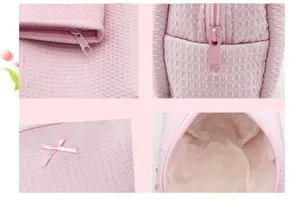 Vistas detalladas del neceser rosa con textura de gofre, cremallera y detalle de lazo
