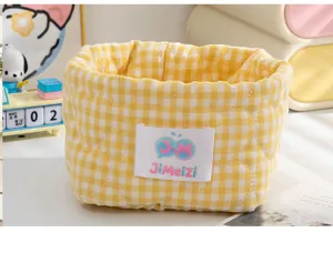 Gros plan d'un panier de rangement en tissu à carreaux jaunes avec motifs de cœur