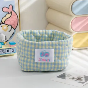 Gros plan d'un panier de rangement en tissu à carreaux bleus et jaunes avec cœurs.