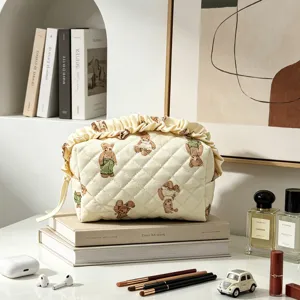 Nahaufnahme einer gesteppten Teddybären-Kosmetiktasche mit elegantem Rüschendesign