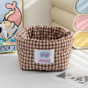 Gros plan d'un panier de rangement en tissu à carreaux marron pour l'organisation du bureau