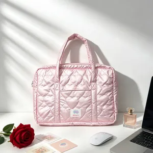 Close-up of pink laptop bag showing heart-shaped quilting and smooth satin texture