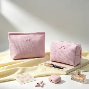 Primer plano de neceseres rosa de tejido gofre con detalle de lazo en un entorno de estilo