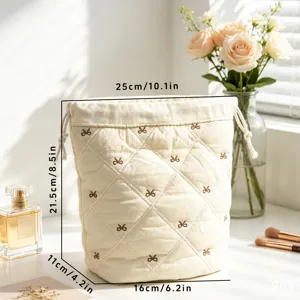 Detailed dimension view of quilted cotton drawstring makeup bag with embroidered bows