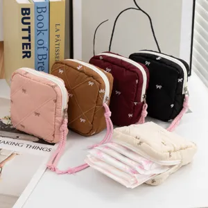 Detailed macro view of quilted bow pouches showing storage capacity for sanitary napkins