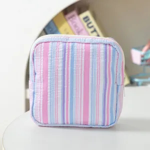 Close-up of striped seersucker storage pouch with pastel pink and blue vertical lines