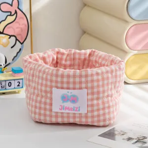 Détail d'un panier de rangement en tissu à carreaux rose et blanc avec cœurs matelassés
