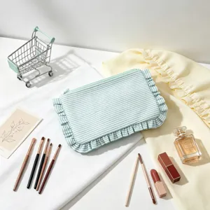 Detailed view of a striped seersucker makeup bag with ruffles in lifestyle setting