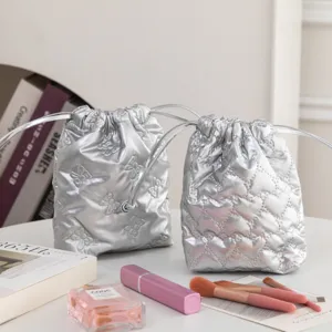 Bolsas plateadas con cordón y patrones de mariposas y corazones acolchados