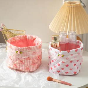 Close-up of two pink quilted fabric storage baskets with cute heart and bear patterns