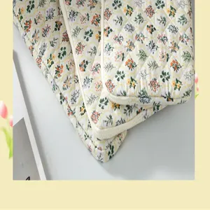 Detailed view of the quilted floral pattern and soft cream piping on the tablet sleeve