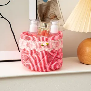 Detail of red striped quilted fabric storage basket with lace and pink rose