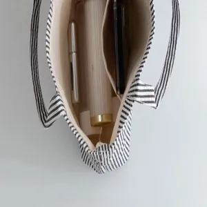 Interior detail of large striped tote bag showing beige lining and inner compartment
