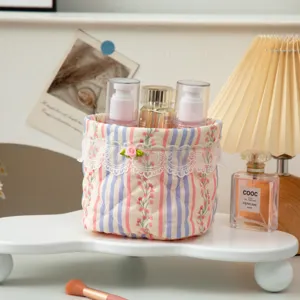 A Korean style quilted floral fabric storage basket with lace trim for desk organization
