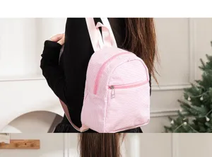 Primer plano de una mochila de seersucker a rayas rosas usada por una modelo joven