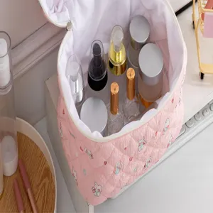 Vista detallada de la bolsa de maquillaje acolchada rosa con gran capacidad y patrones