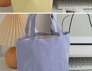 Detailed view of a blue and white striped canvas tote bag in a cozy home setting