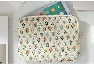 Close-up of vintage floral quilted tablet sleeve showing delicate flower patterns and texture