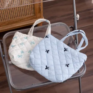 Vista detallada de bolsas de cosméticos acolchadas con lazos en una silla transparente