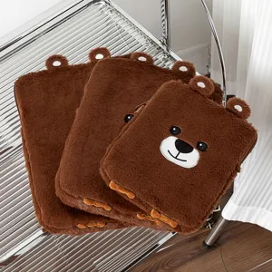Close-up view showing the soft texture of brown plush bear laptop sleeves with embroidery