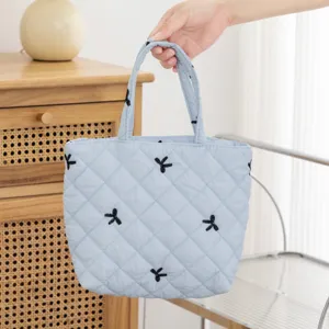 Bolsa de cosméticos acolchada azul claro con bordado negro detallado y elegante