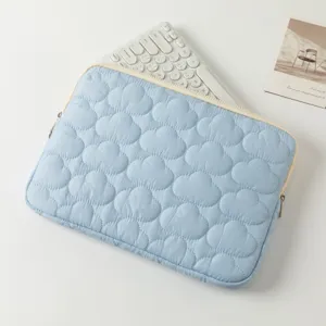 Dettaglio della custodia per laptop trapuntata azzurra con motivo a nuvole e tastiera