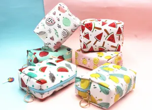 Primer plano de neceseres con motivos de frutas y elegantes cremalleras de aro dorado