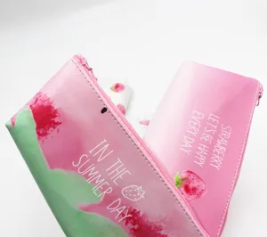 Nahaufnahme von niedlichen Federmäppchen mit Erdbeermuster in Pink und Grün