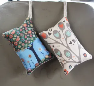 Dos bolsas ambientadoras decorativas para coche con flores y corazones colgadas al asiento.