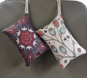 Detalle de dos bolsas decorativas de carbón de bambú para purificar aire en coche