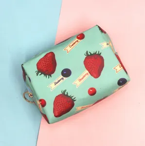 Vista detallada del neceser verde menta con bonitos estampados de fresas y bayas.