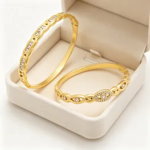 Gouden boze oog en geometrische strassteen roestvrij staal scharnier armbanden detail weergave.