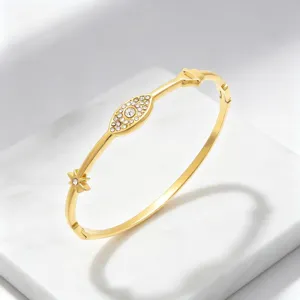 Goudkleurig roestvrij staal boze oog strass armband detail, elegant geometrisch ster design.