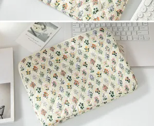 Detailed macro view of a quilted floral tablet sleeve bag placed on a clean office desk setup