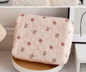 Neceser rosa acolchado con diseño de oso adorable en una bandeja decorativa de madera