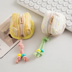 Primer plano de lindos monederos de tweed para auriculares inalámbricos con cordones de colores