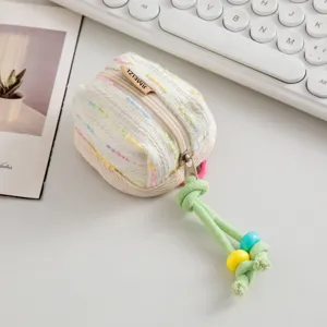 Detalle de funda de tweed para auriculares con cuentas de colores y cordón trenzado